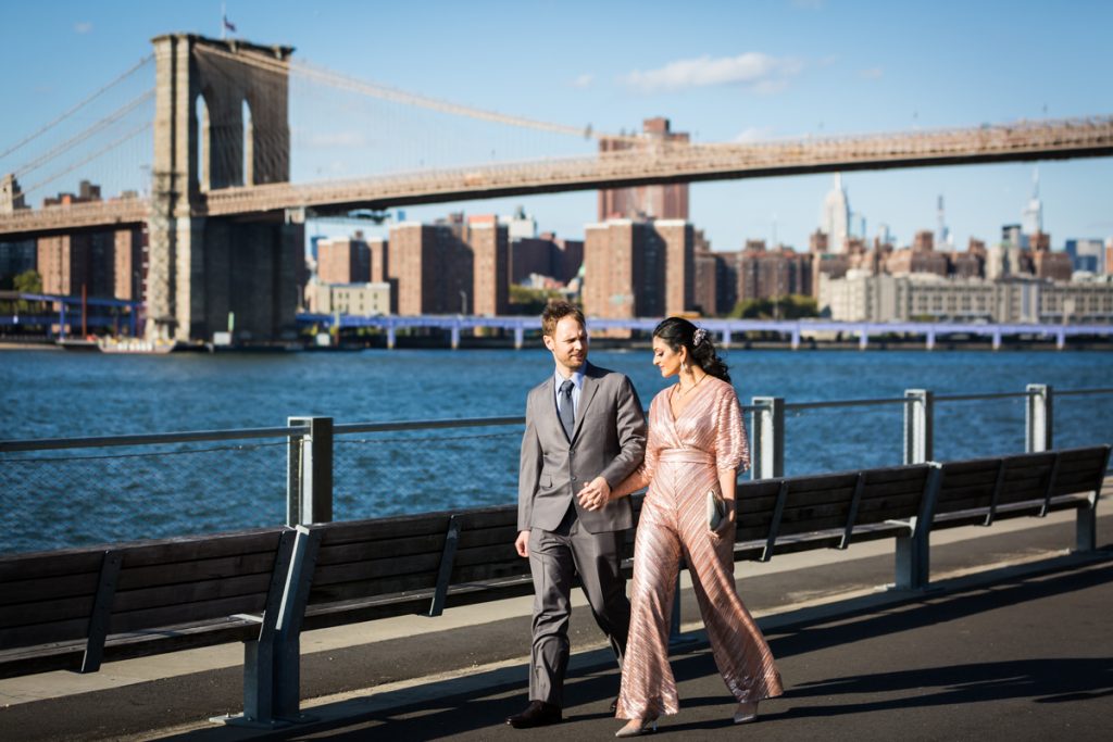 Bride and groom walking with Brooklyn Bridge in background