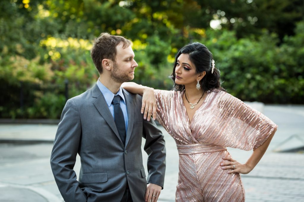 Bride in pink jumpsuit leaning on groom's shoulder for an article on how to get married in Brooklyn Bridge Park