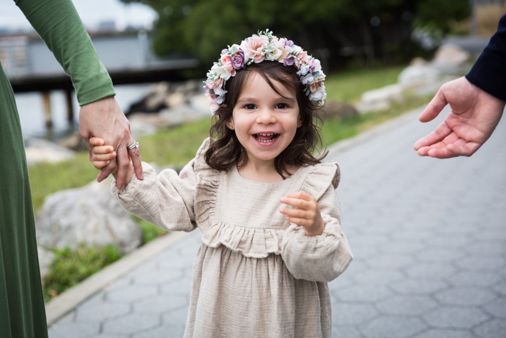 Little girl holding parent's hand and wearing flower crown
