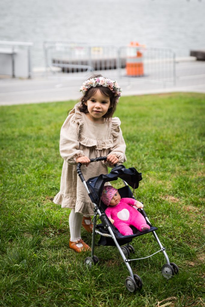 Little girl pushing baby doll in stroller in Riverside Park
