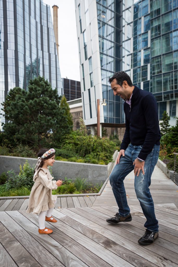 Father and daughter dancing on boardwalk of Waterline Square Park