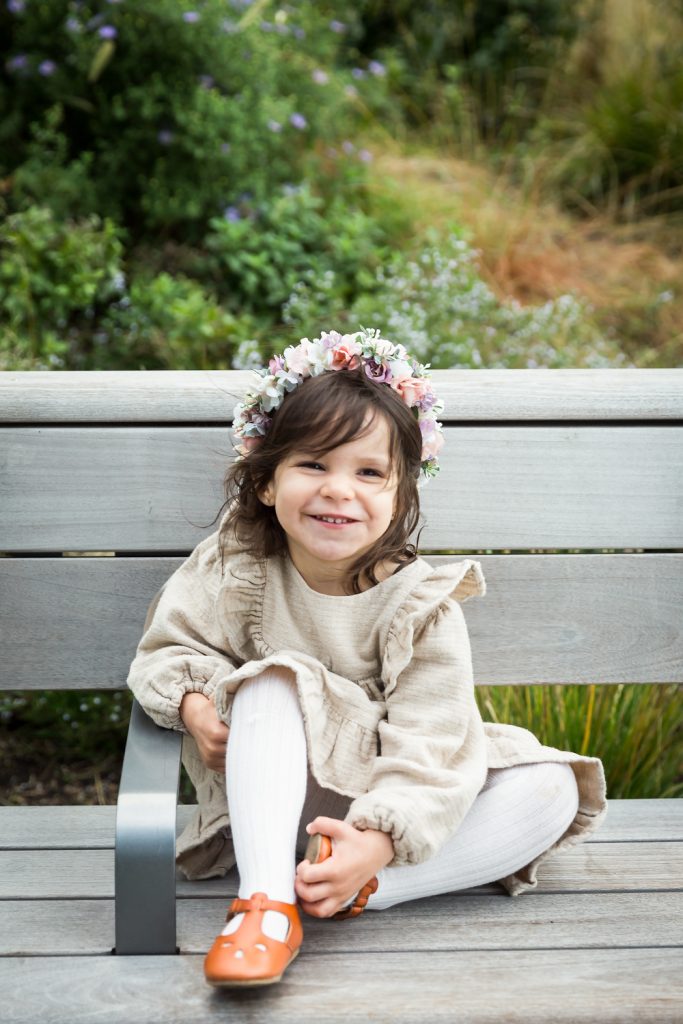 Little girl wearing flower crown on bench in Waterline Square Park