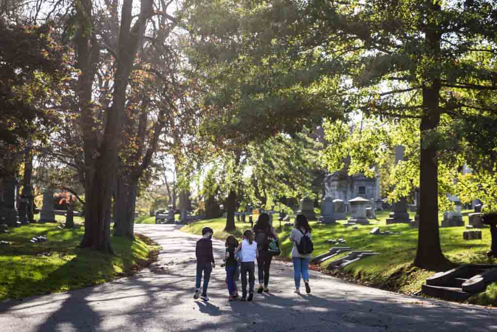 Moms and kids walking along pathways for an article on visiting Green-Wood Cemetery