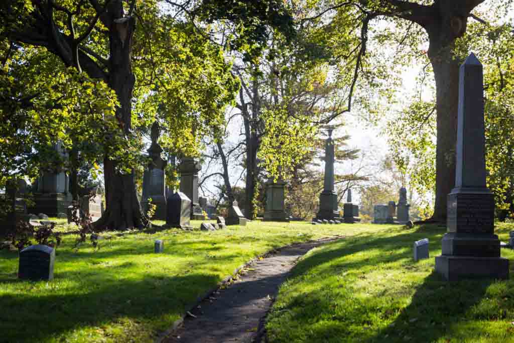 Graves and sunlit pathway at Green-Wood Cemetery