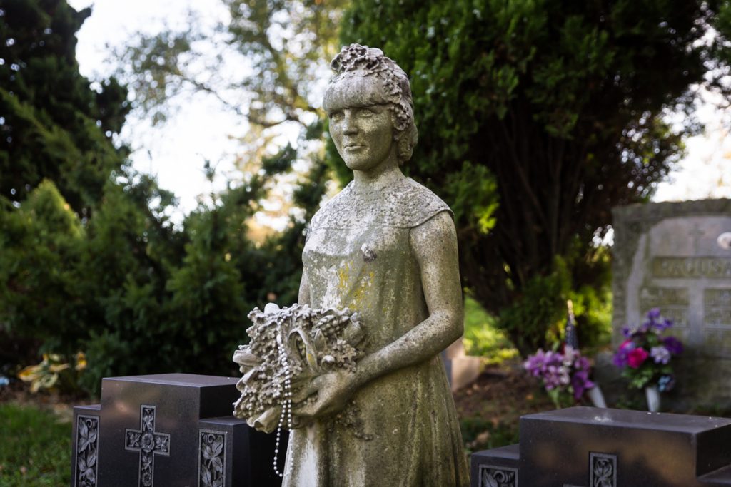 Statue of woman holding flowers at Green-Wood Cemetery