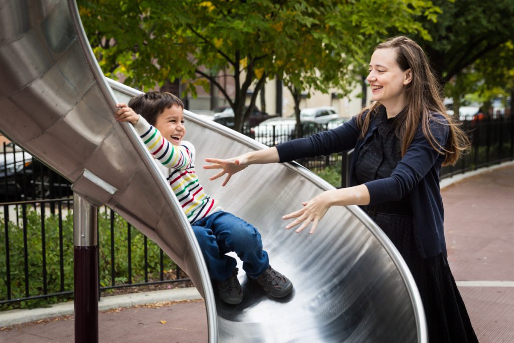 Mother catching boy going down slide at an Ennis Playground family portrait session