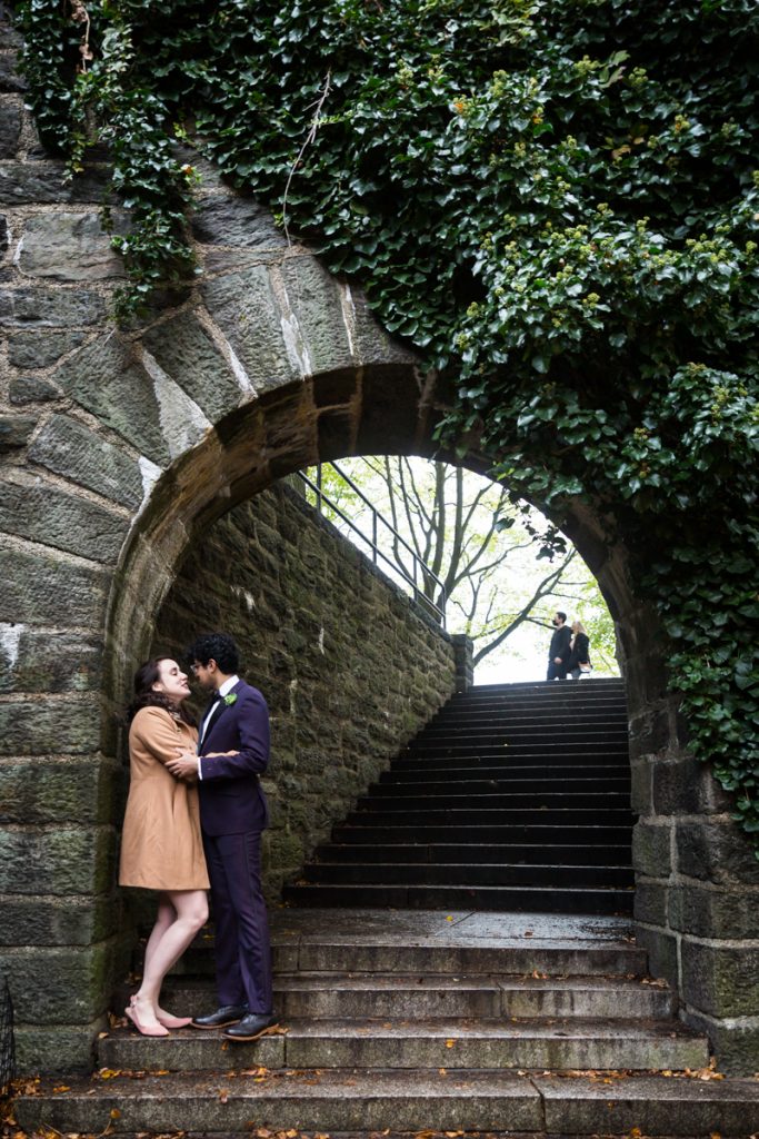 Couple kissing under stone archway in Fort Tryon Park