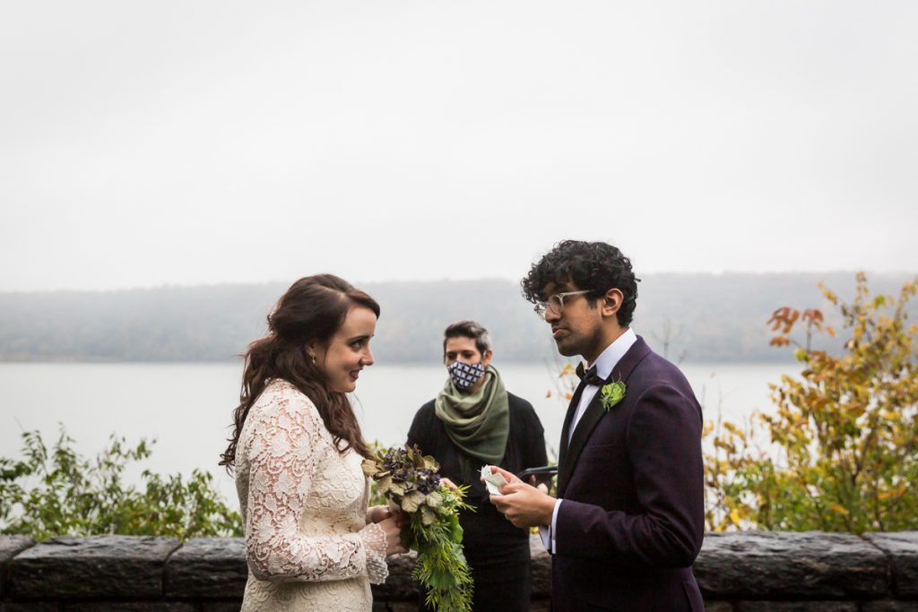 Couple swapping vows with view of Hudson River for an article on how to get married in Fort Tryon Park