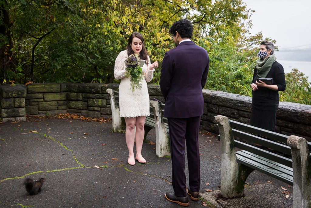 Couple exchanging vows in Fort Tryon Park with squirrel watching