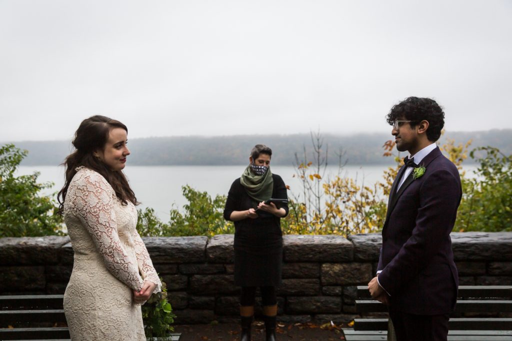 Bride and groom listening to officiant during Fort Tryon Park wedding ceremony