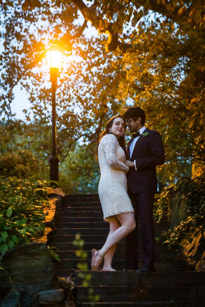 Couple hugging under a lamp post in the Heather Garden in Fort Tryon Park