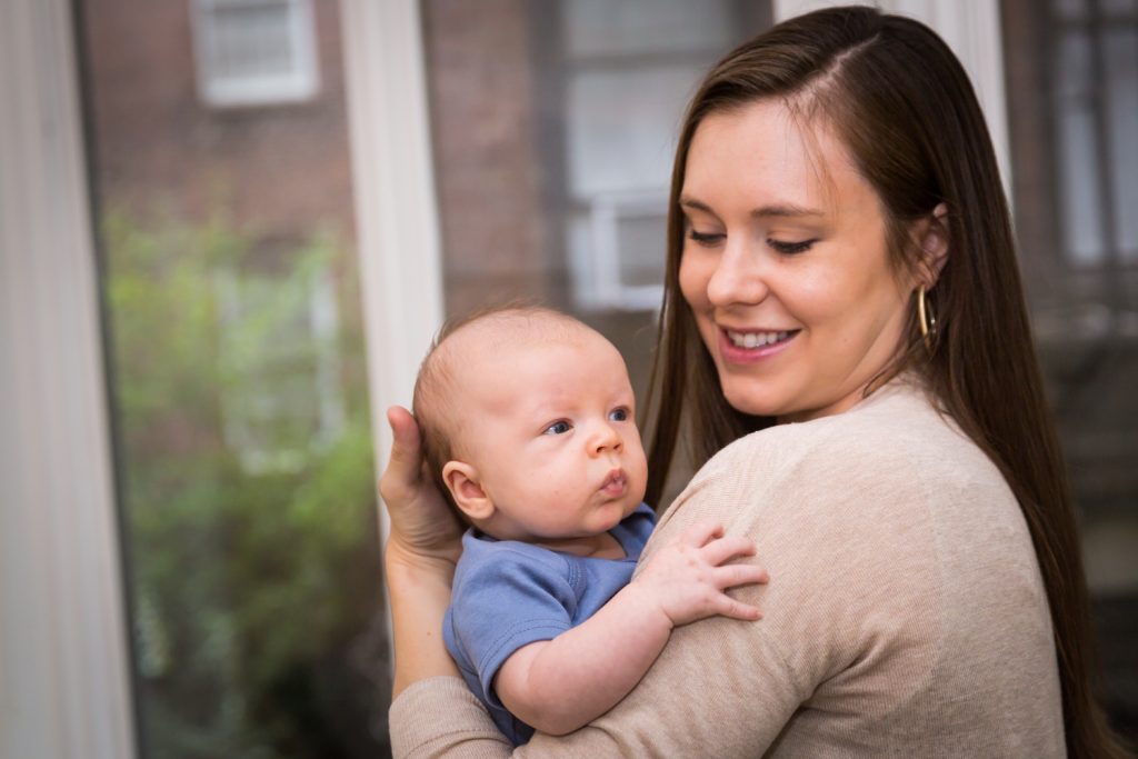 Mother holding newborn son for an article on how to prepare for a newborn portrait session
