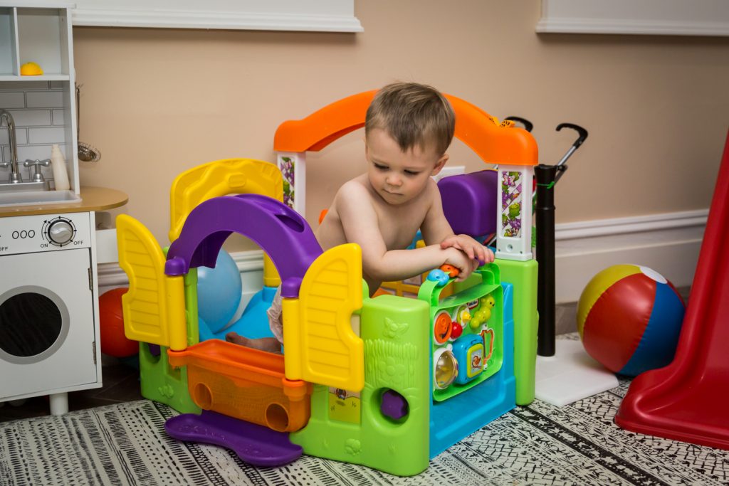 Little boy playing in colorful play castle