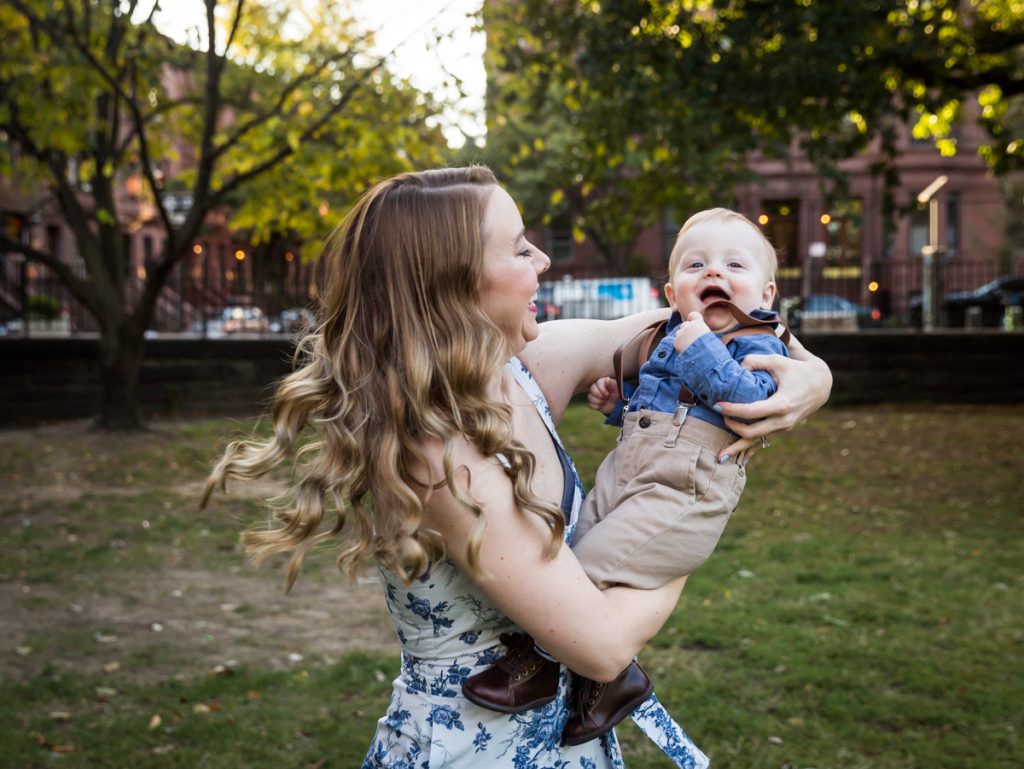 Mother swinging baby son during a Marcus Garvey Park family portrait session