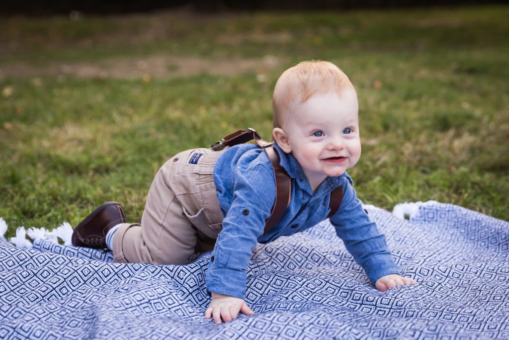 Baby boy crawling on blue blanket in Marcus Garvey Park