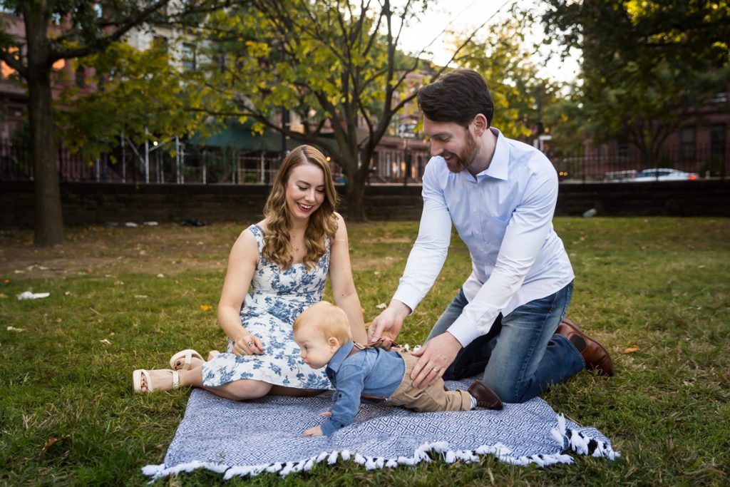Parents with baby boy on blue blanket in Marcus Garvey Park