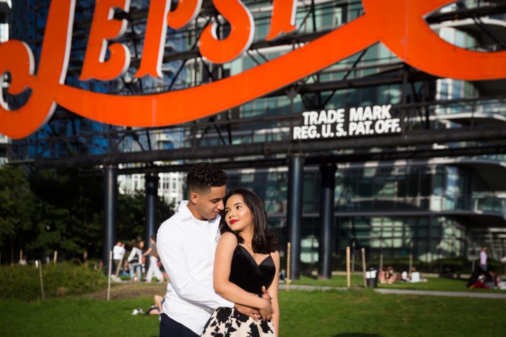 Couple hugging in front of Pepsi Cola neon sign in Gantry Plaza State Park