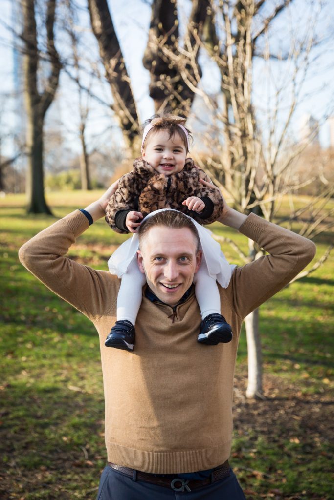 Father holding little girl on his shoulders in Central Park