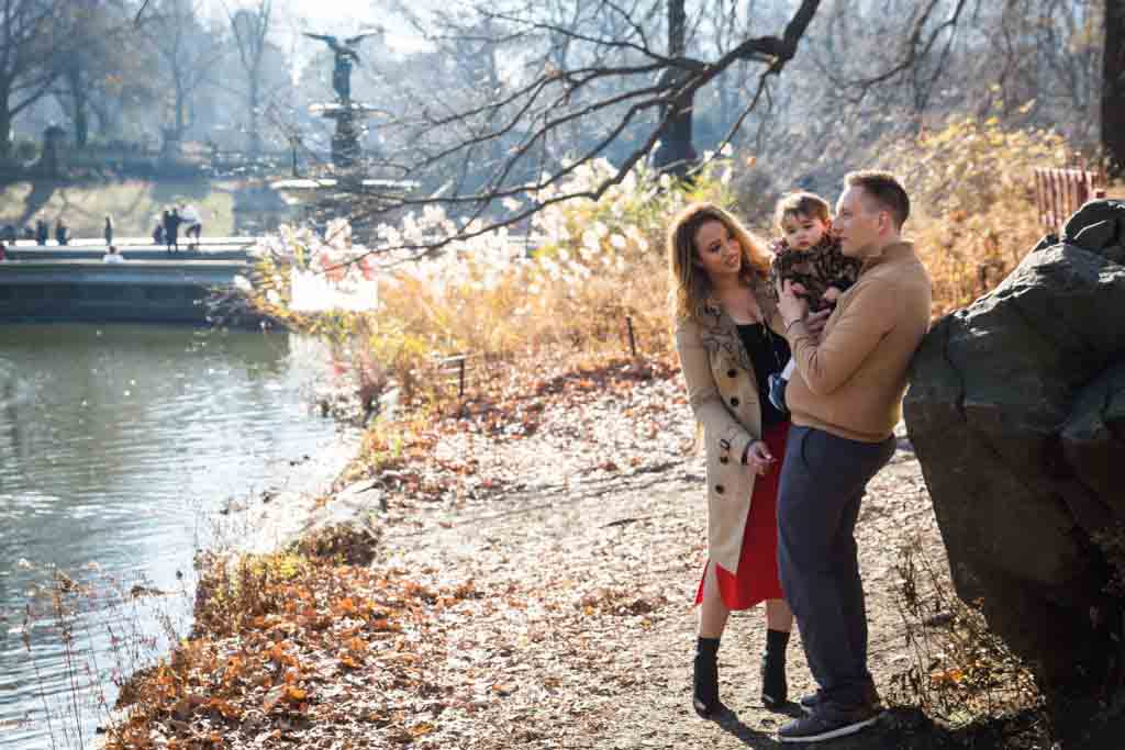 Parents and little girl standing by Central Park Lake