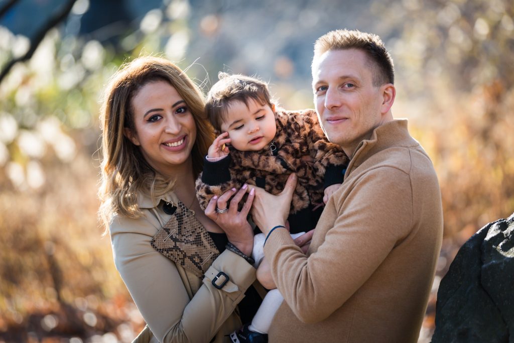 Parents holding baby girl for an article on Central Park holiday portrait tips