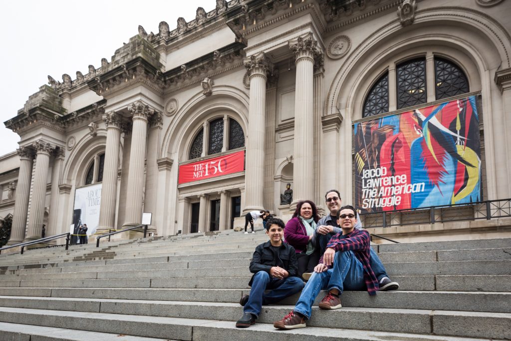 Family sitting on the steps of the Metropolitan Museum of Art in NYC