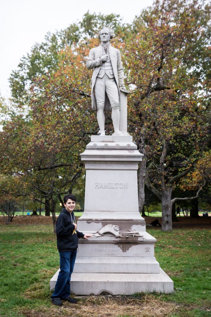 Young man in front of Alexander Hamilton statue in Central Park