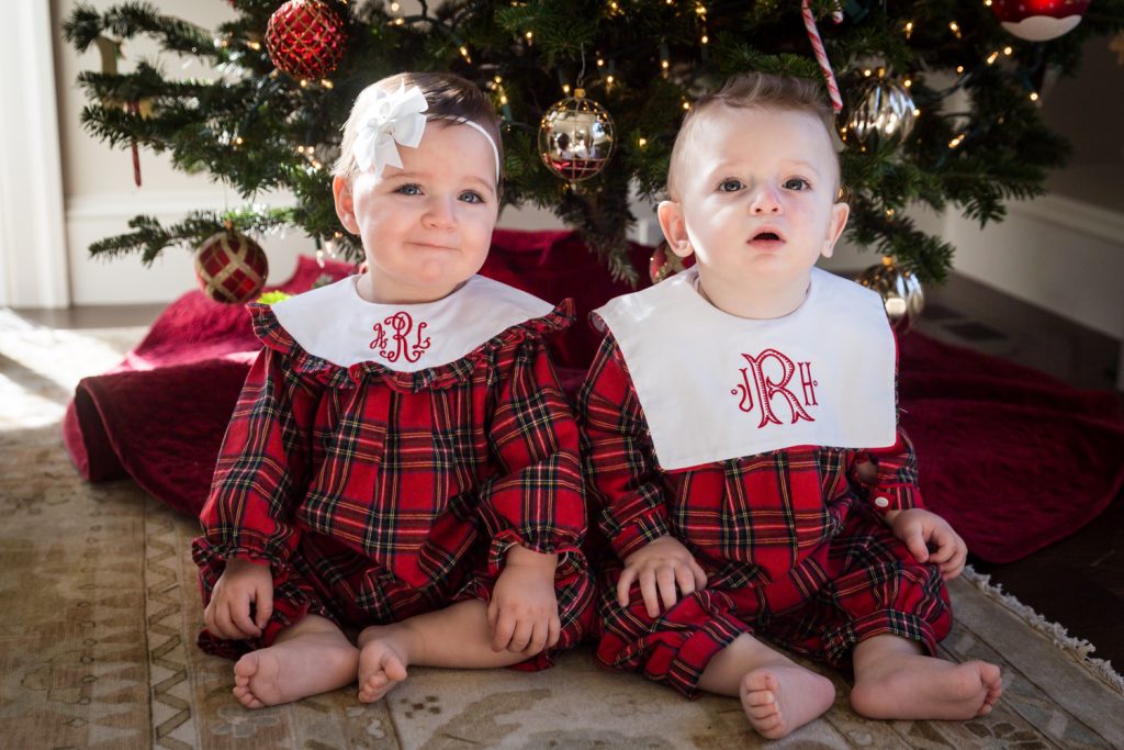Two babies in matching plaid pajamas for an article on holiday family portrait ideas