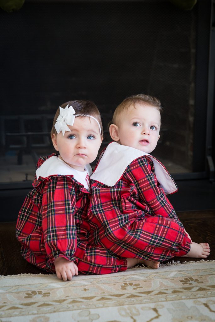 Twin babies wearing matching plaid pajamas