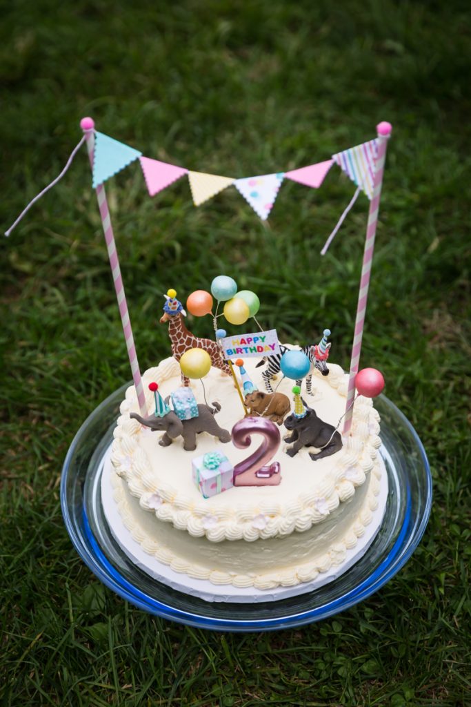 Birthday cake with number 2 candle and zoo animal cake toppers