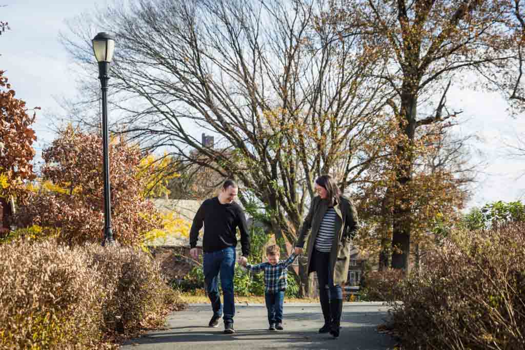 Parents holding little boy by his arms for an article about a Forest Park photo shoot neighborhood discount offer