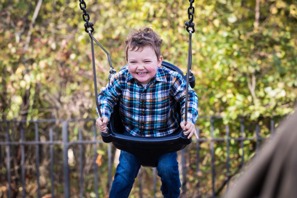Little boy swinging in Forest Park playground