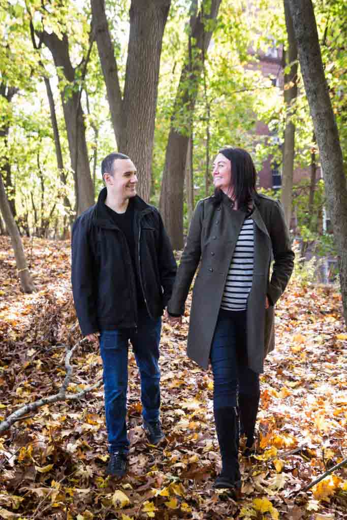 Couple holding hands and walking in woods Parents holding little boy in front of plants for an article about a Forest Park photo shoot neighborhood discount offer