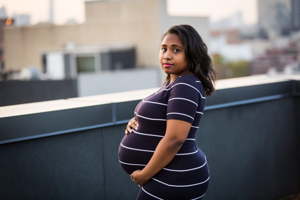 African American pregnant woman holding stomach