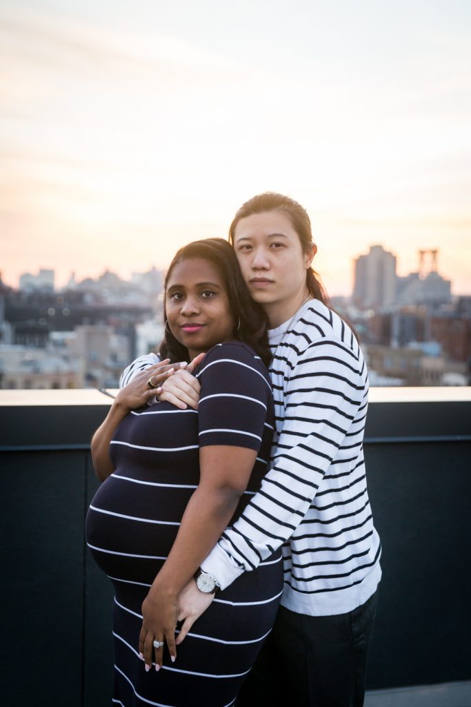 Couple hugging closely at sunset during maternity portrait photo shoot