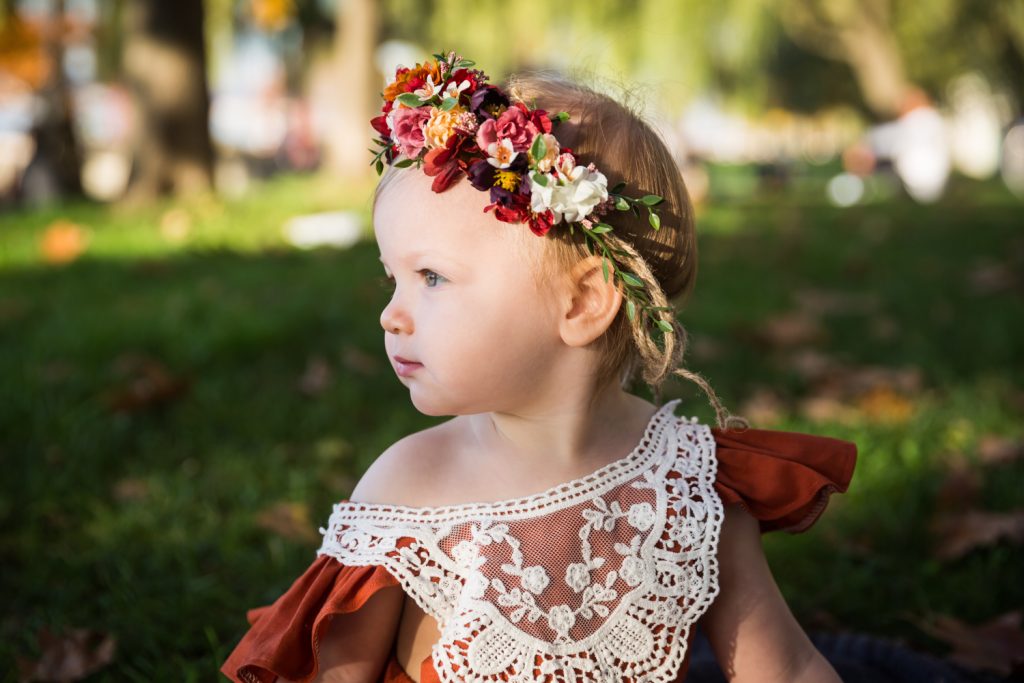 Profile photo of little girl wearing lace outfit and flowers in her hair
