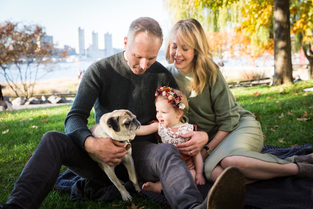 Parents watching little girl pet dog for an article NYC golden hour portrait tips