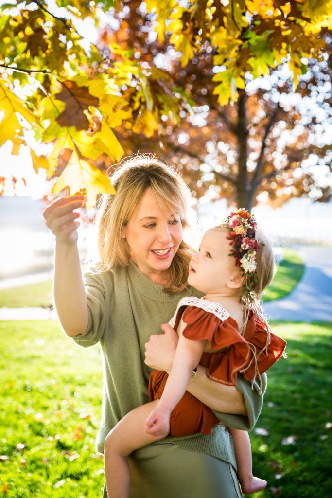 Mother showing leaf to baby girl for an article NYC golden hour portrait tips