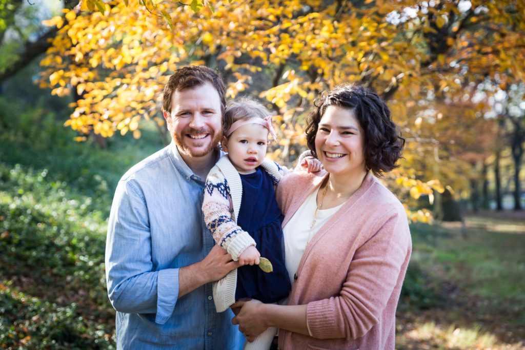 Riverside Park family photos of parents with little girl in front of yellow leaves