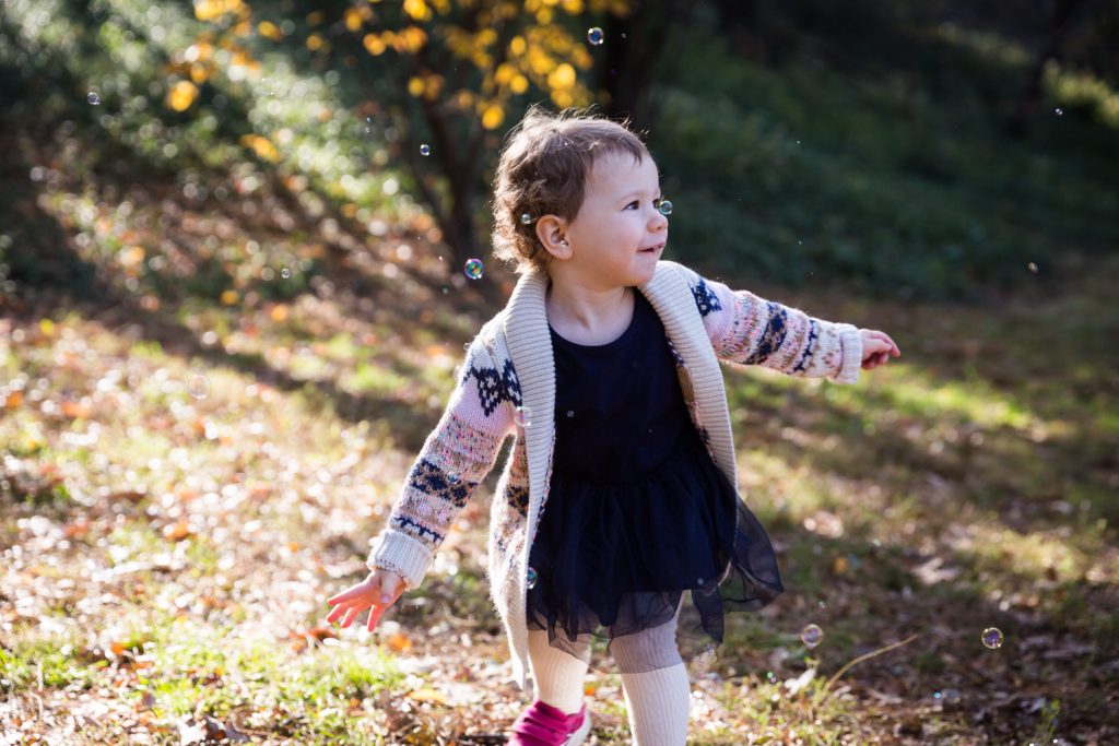 Riverside Park family photos of little girl chasing bubbles