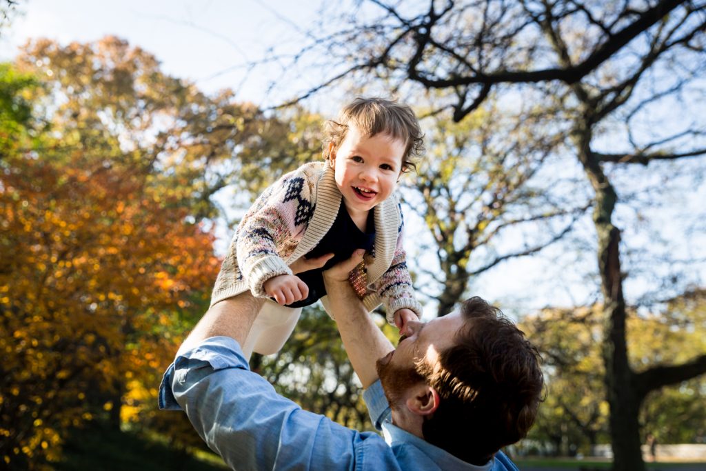 Riverside Park family photos of father holding little girl in the air