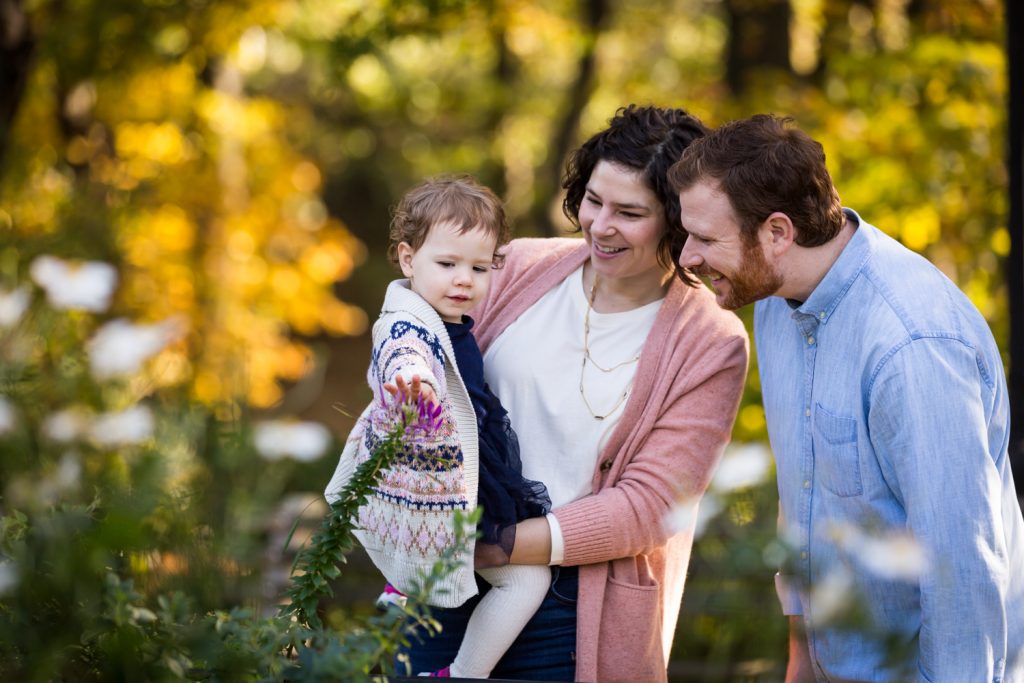 Riverside Park family photos of parents pointing out flower to little girl