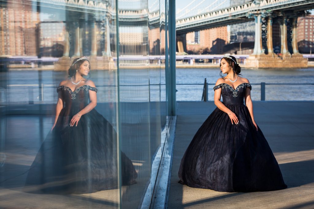 Reflection in window of girl wearing strapless ball ground Girl wearing tiara and coat with fur hood for an article on cold weather portrait tips