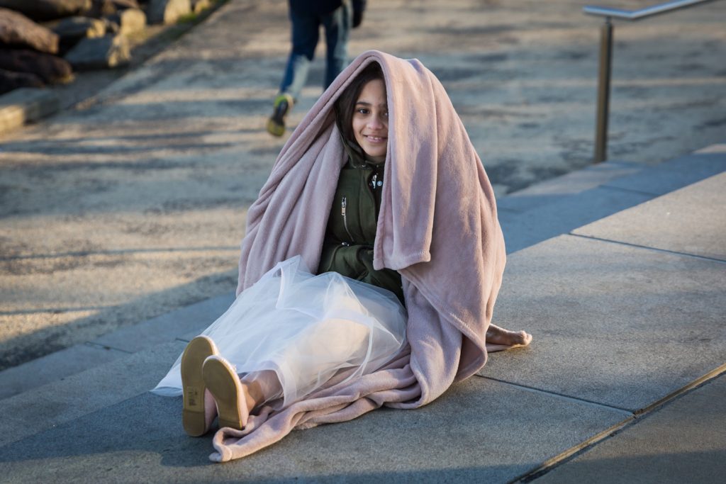 Young girl wearing blanket over her head Girl wearing tiara and coat with fur hood for an article on cold weather portrait tips