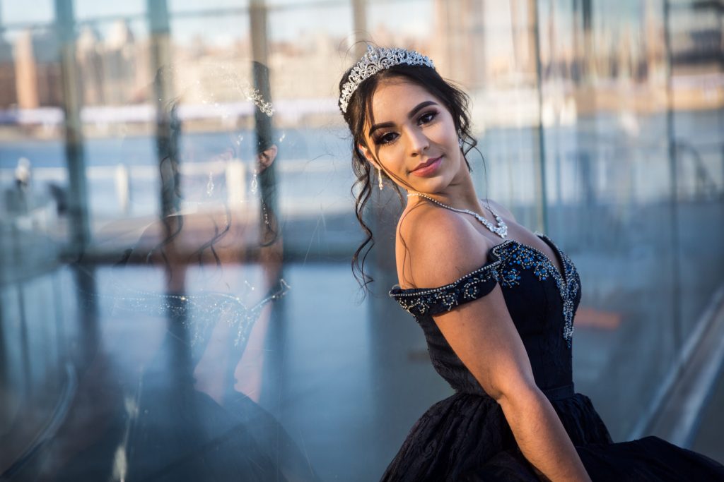 Girl wearing tiara and leaning against glass wall