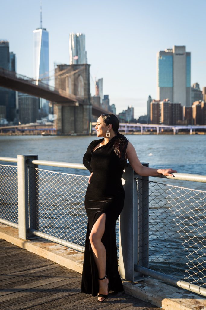 Woman on Brooklyn Bridge Park boardwalk wearing long black dress with split