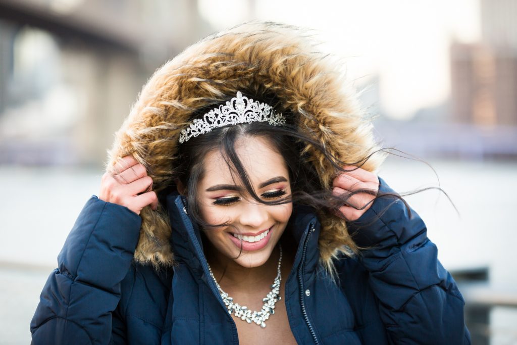Girl holding fur hood of jacket and wearing tiara