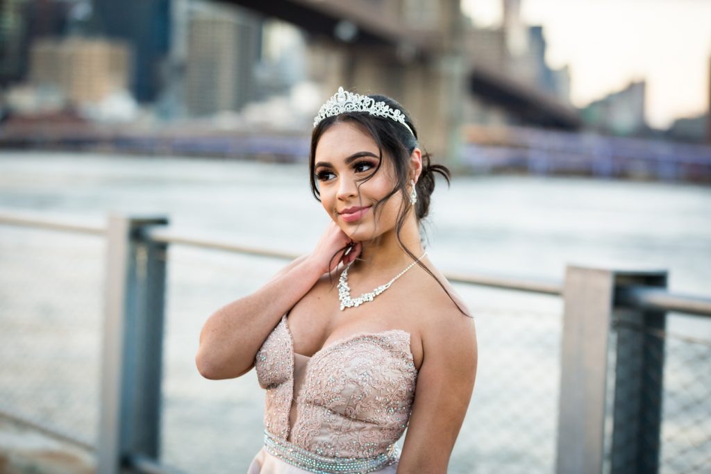 Girl wearing tiara and pink strapless gown on Brooklyn Bridge Park boardwalk