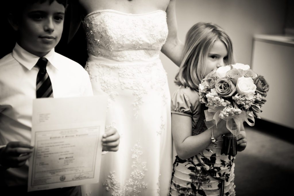 Little girl sniffing the bouquet at a NYC City Hall wedding, by Kelly Williams