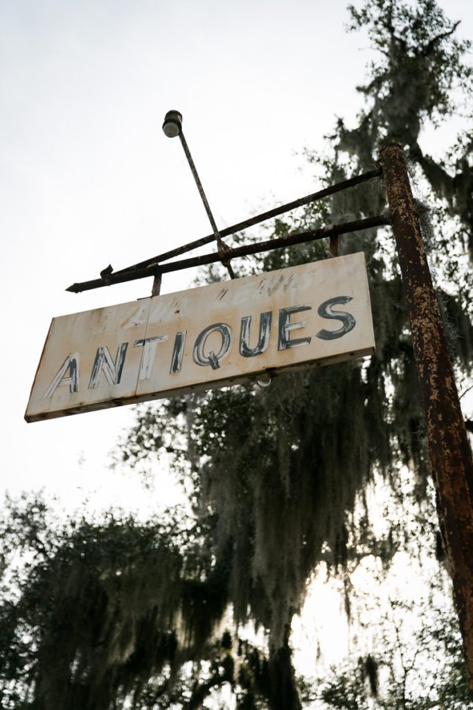 A faded sign for an antiques store