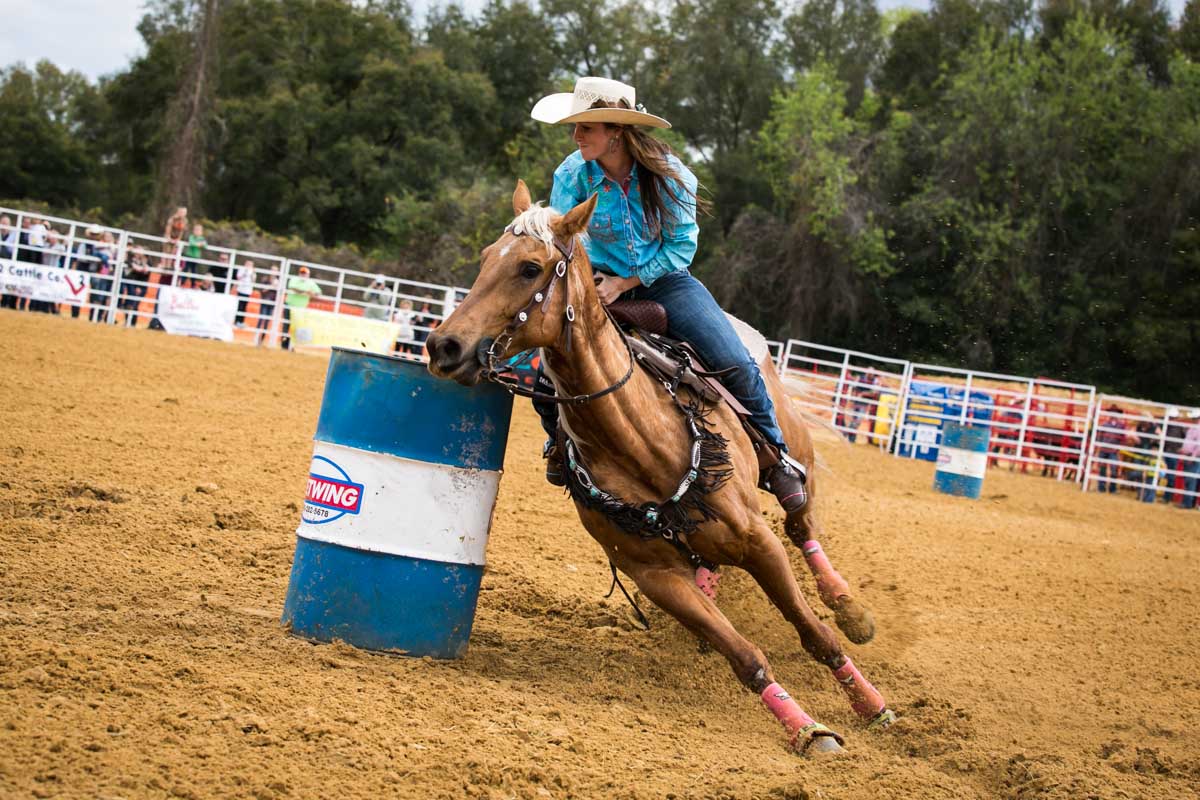 Barrel racing at the county fair championship rodeo, by NYC photojournalist, Kelly Williams